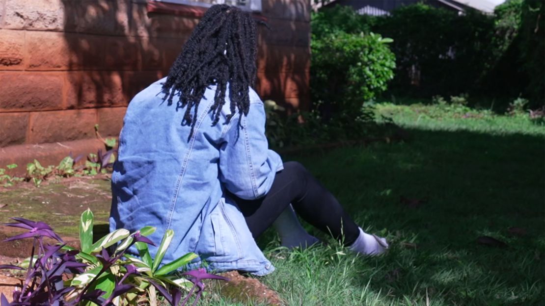 Ann, who fled Uganda, sits in the garden of the safe house in Kenya. She does not feel it's safe to venture further outside.