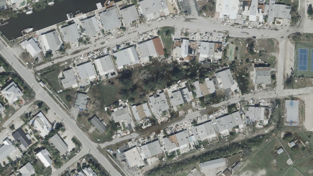 Puddles from Hurricane Milton's storm surge are seen in an area of Holmes Beach on Anna Maria Island, Florida.?On the edges of the flooded area sits debris piles from damage caused by Hurricane Helene's own storm surge on the island.