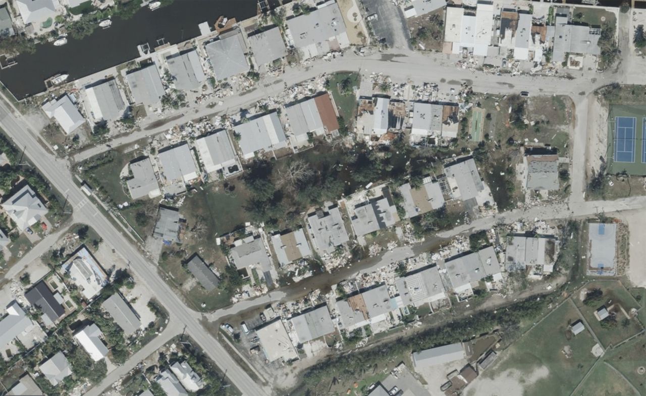 Puddles from Hurricane Milton's storm surge are seen in an area of Holmes Beach on Anna Maria Island, Florida. On the edges of the flooded area sits debris piles from damage caused by Hurricane Helene's own storm surge on the island.