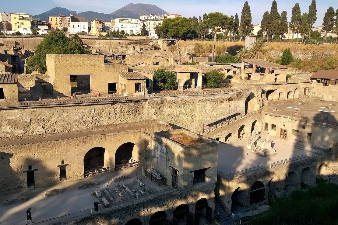 Mount Vesuvius is visible in the background at the archaeological site of Herculaneum.