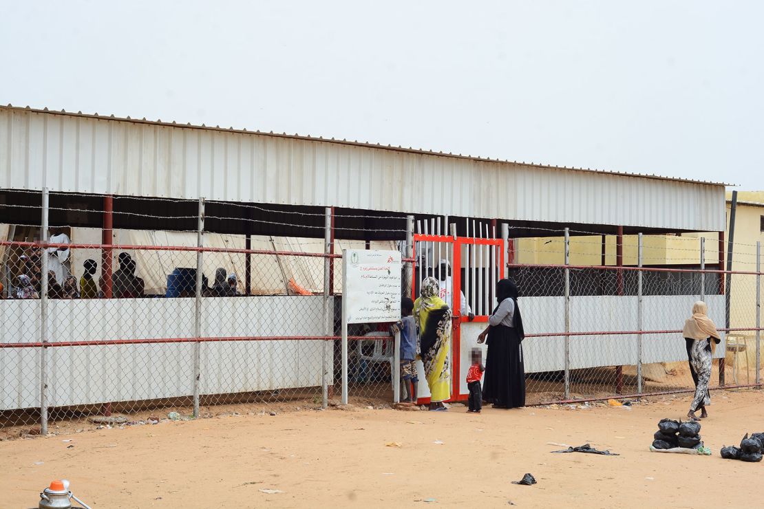 People wait outside an MSF clinic, which offers treatment for malnutrition patients in Zamzam camp, in February of 2024. CNN has obscured portions of this image to protect the identities of individuals pictured.