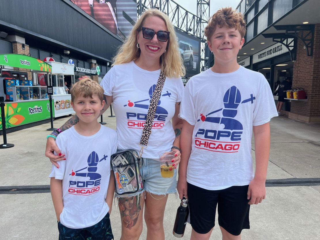 Irene Richardson and her two sons at Rate Field wearing their new pope-themed T-shirts.