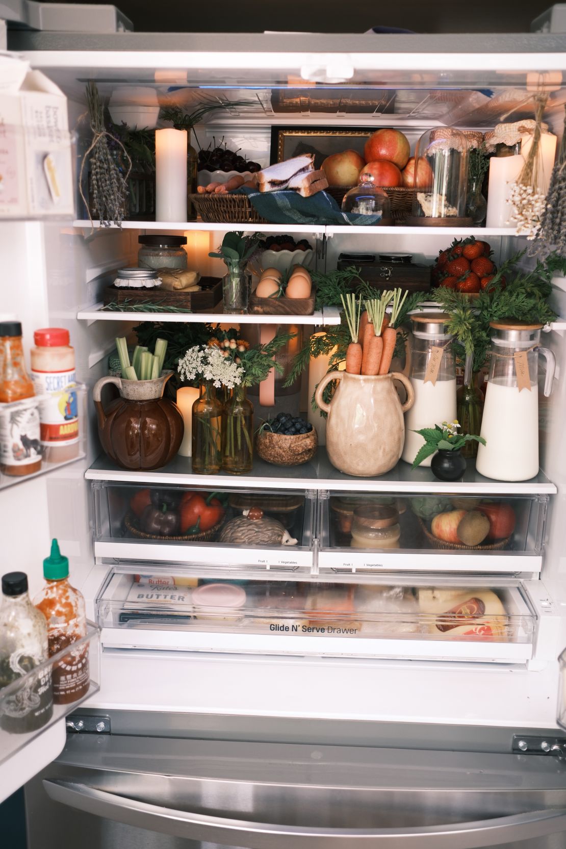 Lynzi Judish's fridgescapes involve neatly arranging produce and adding in touches like fresh flowers or food-safe trinkets.