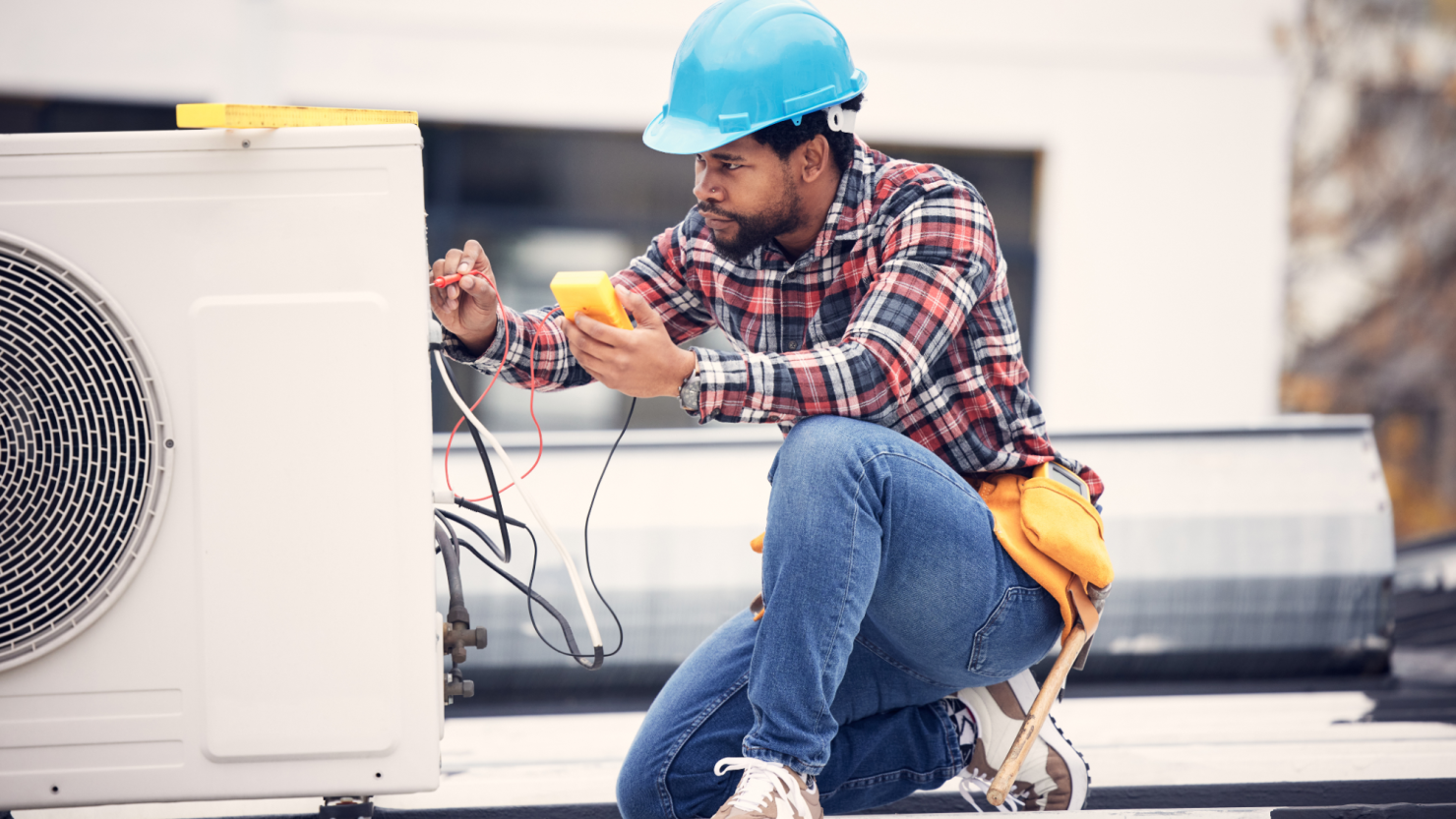 Technician works on air conditioning unit