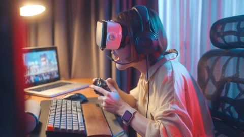 Teenager playing video games on a virtual reality headset.