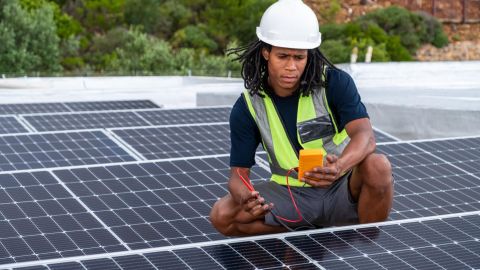 Solar installer checking the output of rooftop solar panels.