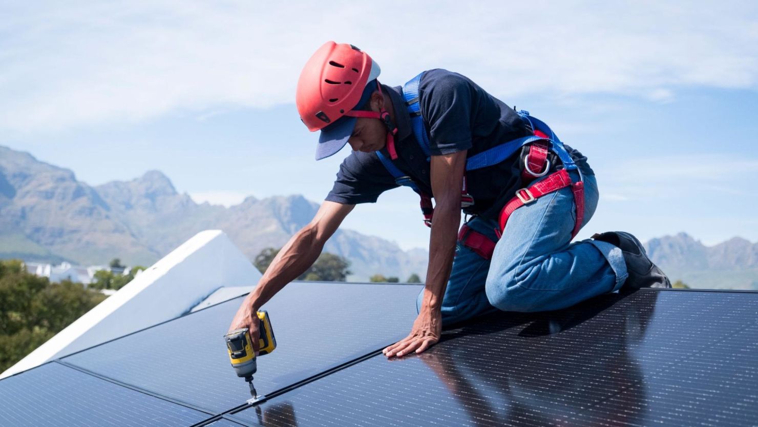 Solar technician installing solar panels on a residential roof.