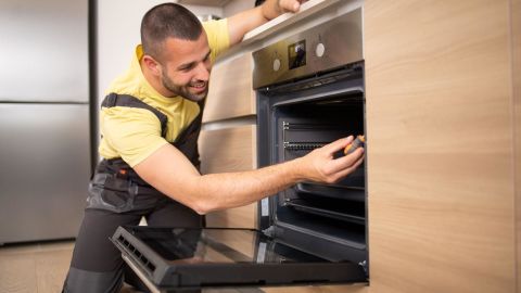 Service technician fixing a broken oven.