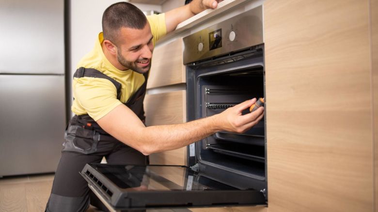 Service technician fixing a broken oven.