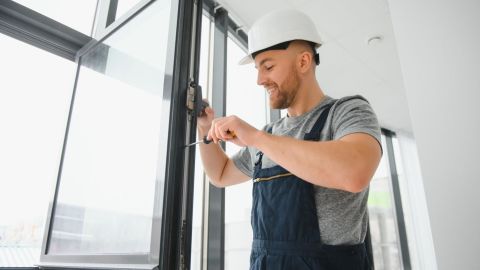 Window replacement technician adjusting the hinge on a window.