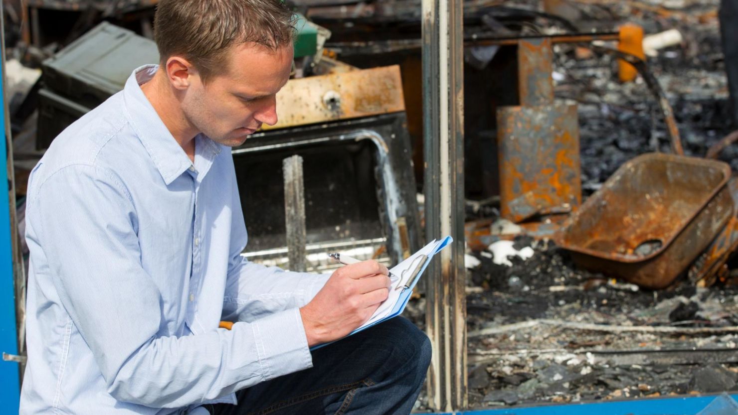 Fire damage restoration specialist documenting damage after a house fire.