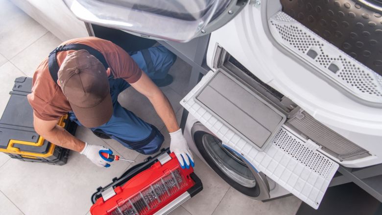 Service technician fixing a washing machine.