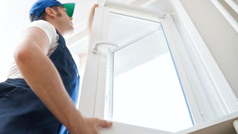 Window installer putting in a window inside a home.