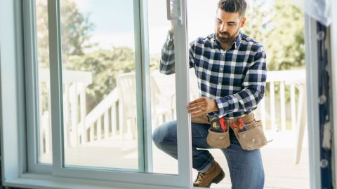 Window installer aligning a sliding glass door.