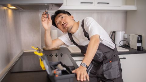 Service technician fixing a range hood