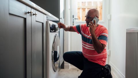 Homeowner calling their home warranty provider to get their washer fixed.