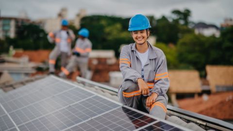 Solar installer sitting on a rooftop solar system.