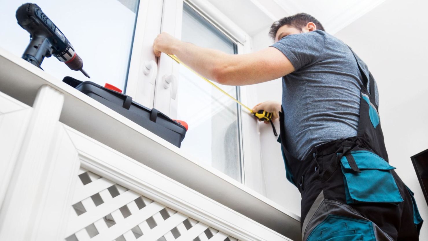 Window installer measuring the size of a window