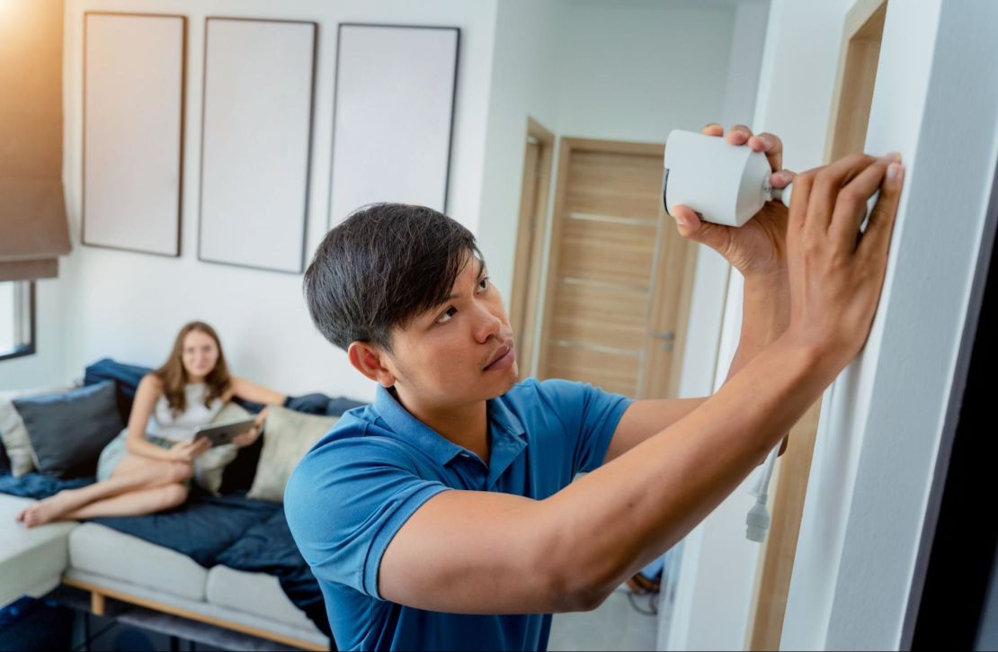 Homeowner installing an indoor home security camera.