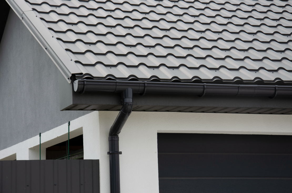 Black plastic half-round gutter and metal tiled roof