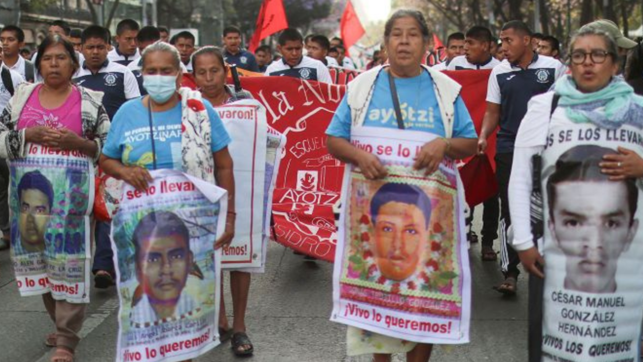 Estudiantes acompañan a familiares de los 43 estudiantes desaparecidos de la Normal Rural de Ayotzinapa y a  de colectivos de familiares de desaparecidos durante la marcha mensual de Ayotzinapa para exigir justicia en la Ciudad de México.
