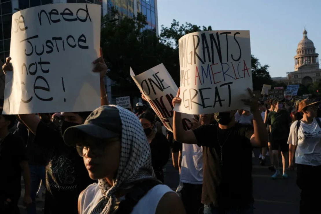 Manifestantes sostienen pancartas el lunes durante una manifestación en Austin, Texas, oponiéndose a las redadas migratorias.