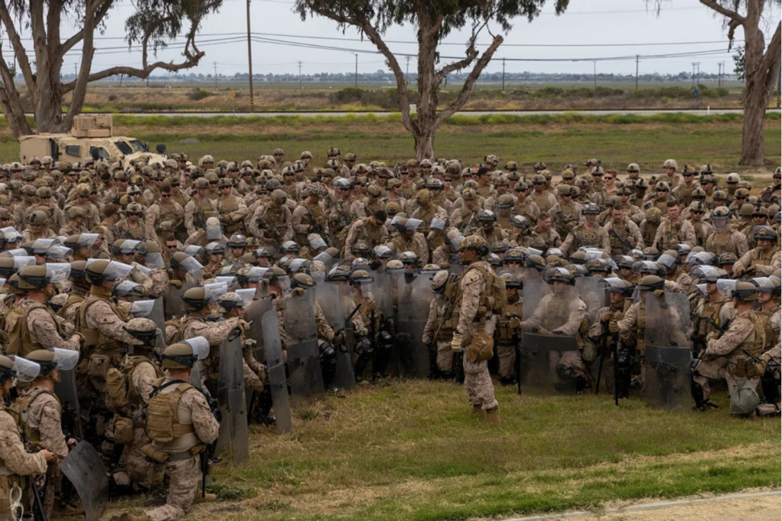 Infantes de Marina de EE.UU. del 2.º Batallón, 7.º Regimiento de Infantería de Marina, 1.ª División de Infantería de Marina, que se encontraban en estado de alerta durante el fin de semana, reciben instrucciones de la jefatura del batallón mientras ensayan tácticas de control de multitudes en una base del área metropolitana de Los Ángeles el martes.