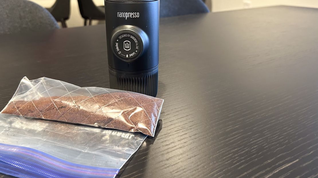 Nanopresso espresso machine placed on table next to a bag of coffee grounds.