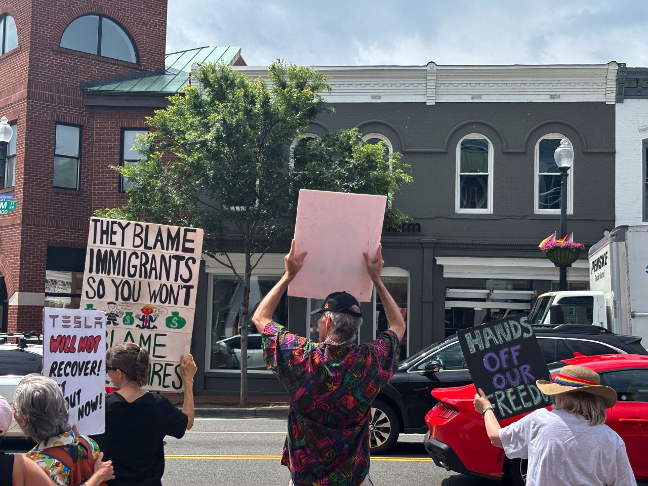 People demonstrate outside a Tesla store in Washington, DC on Saturday.