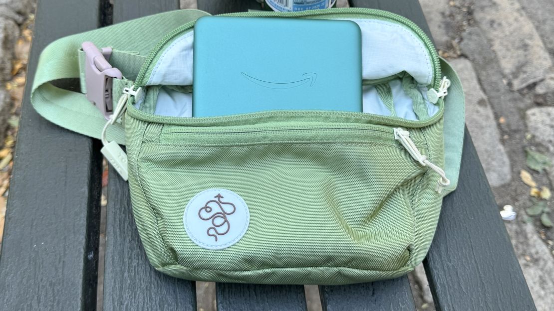 Amazon Kindle Paperwhite Signature Edition sticks out of a green fanny pack