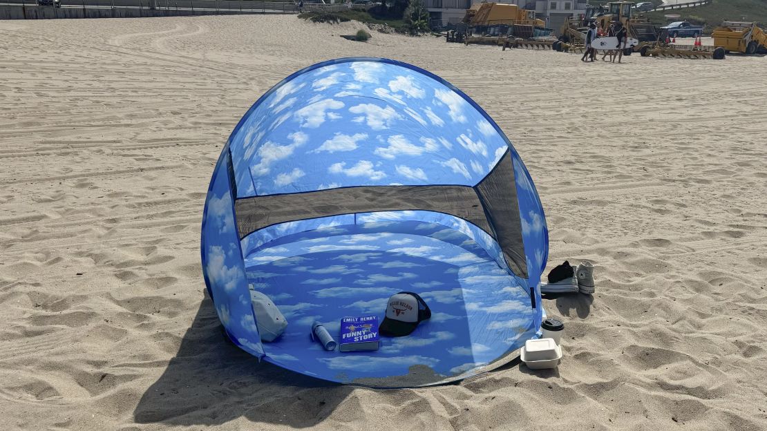 Front of Baggu Pop Up tent with book, hat, sunscreen and small bag inside.