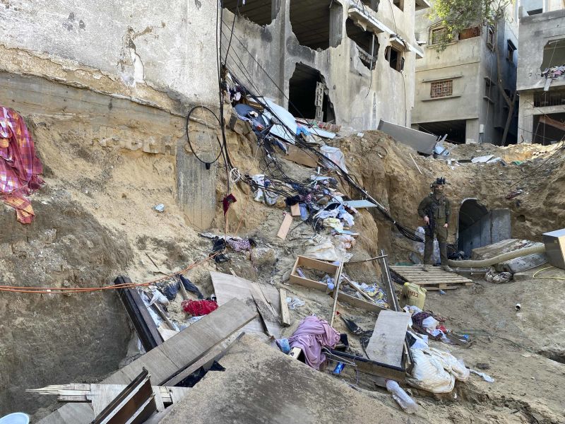 An Israeli soldier stands guard outside the entrance to a tunnel network underneath a destroyed neighborhood in Khan Younis.