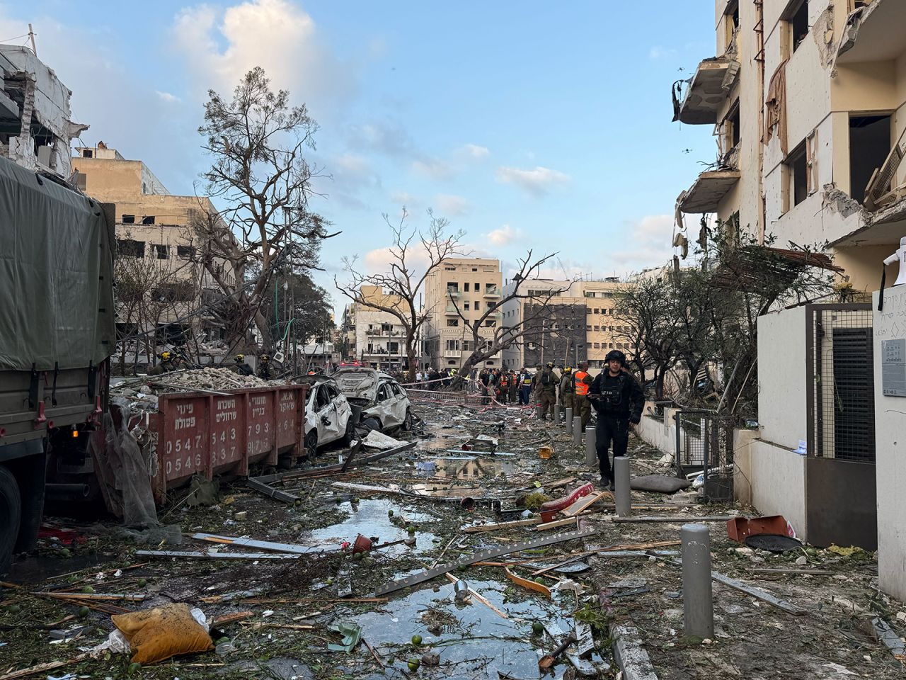 A street in Tel Aviv is covered in debris as emergency workers search the area after an Iranian missile strike on Monday.