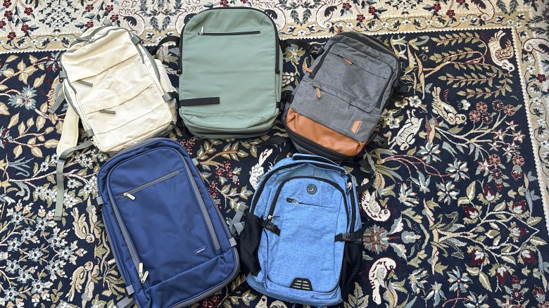 A photo of five travel backpacks on a blue carpet with a pattern