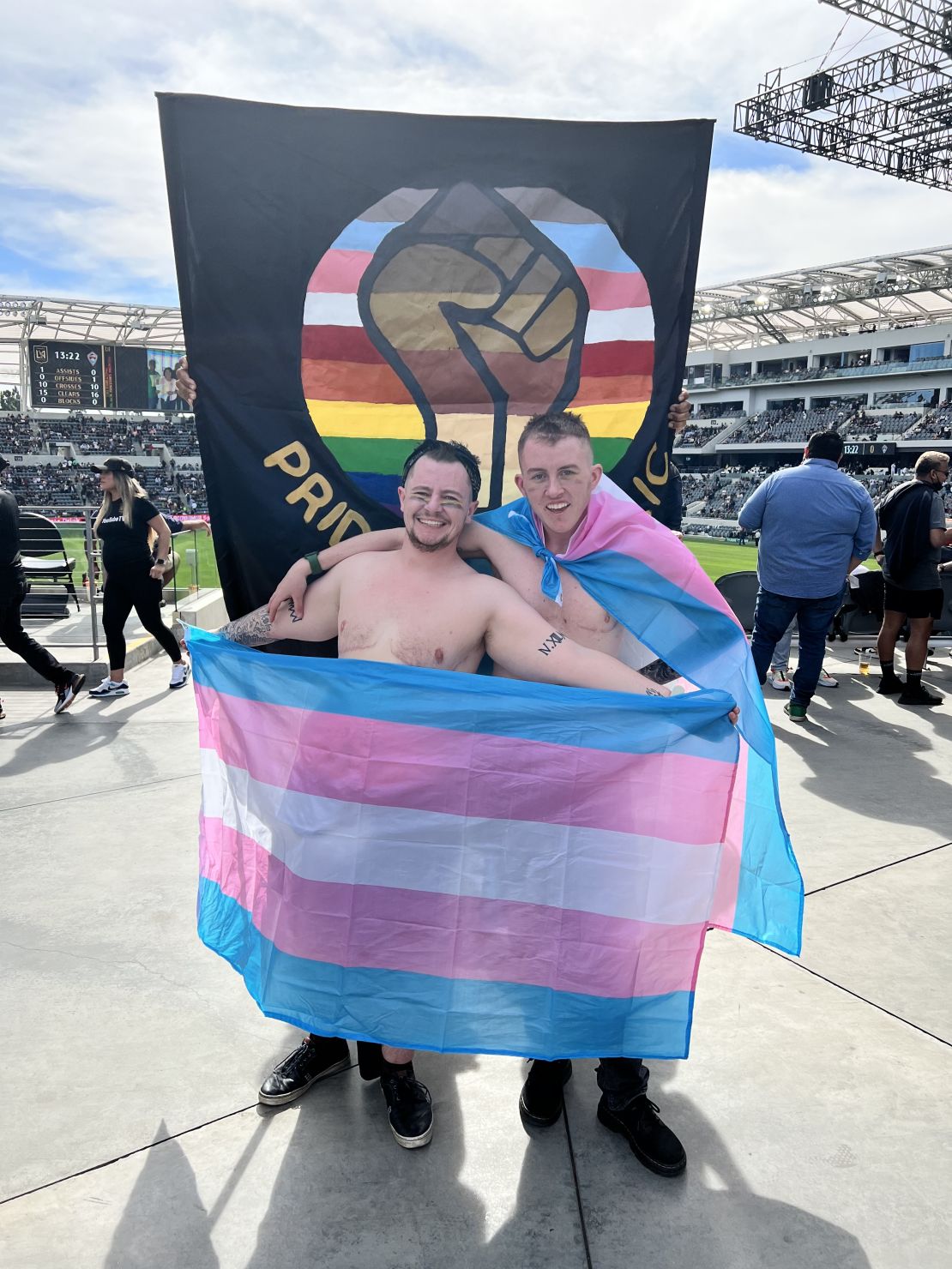 Taylor Gray and his husband, Max, hold the transgender pride flag at LAFC'S BMO Stadium.