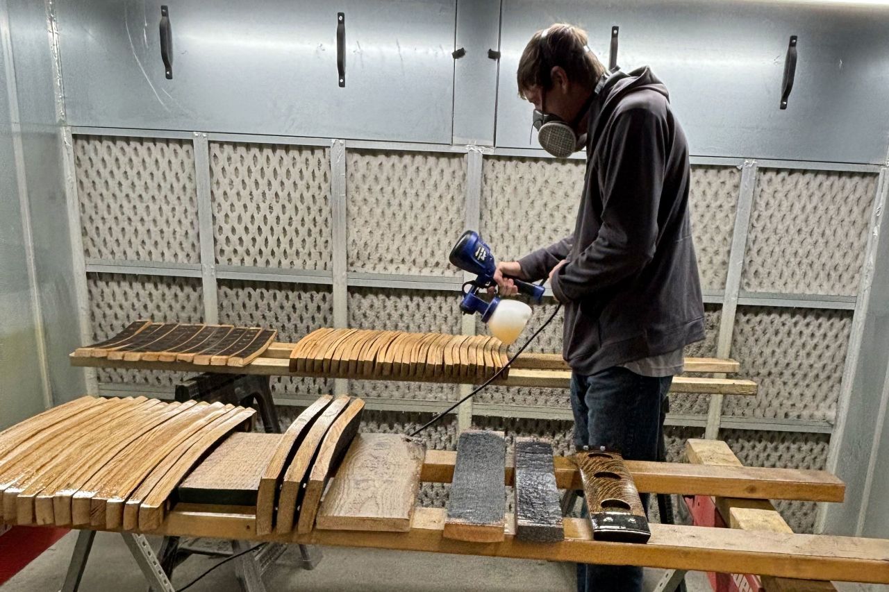 Michael Prieto, owner of Barrel-Art, sprays a clear coat finish on products in his shop in Newport News, Virginia, on November 13.