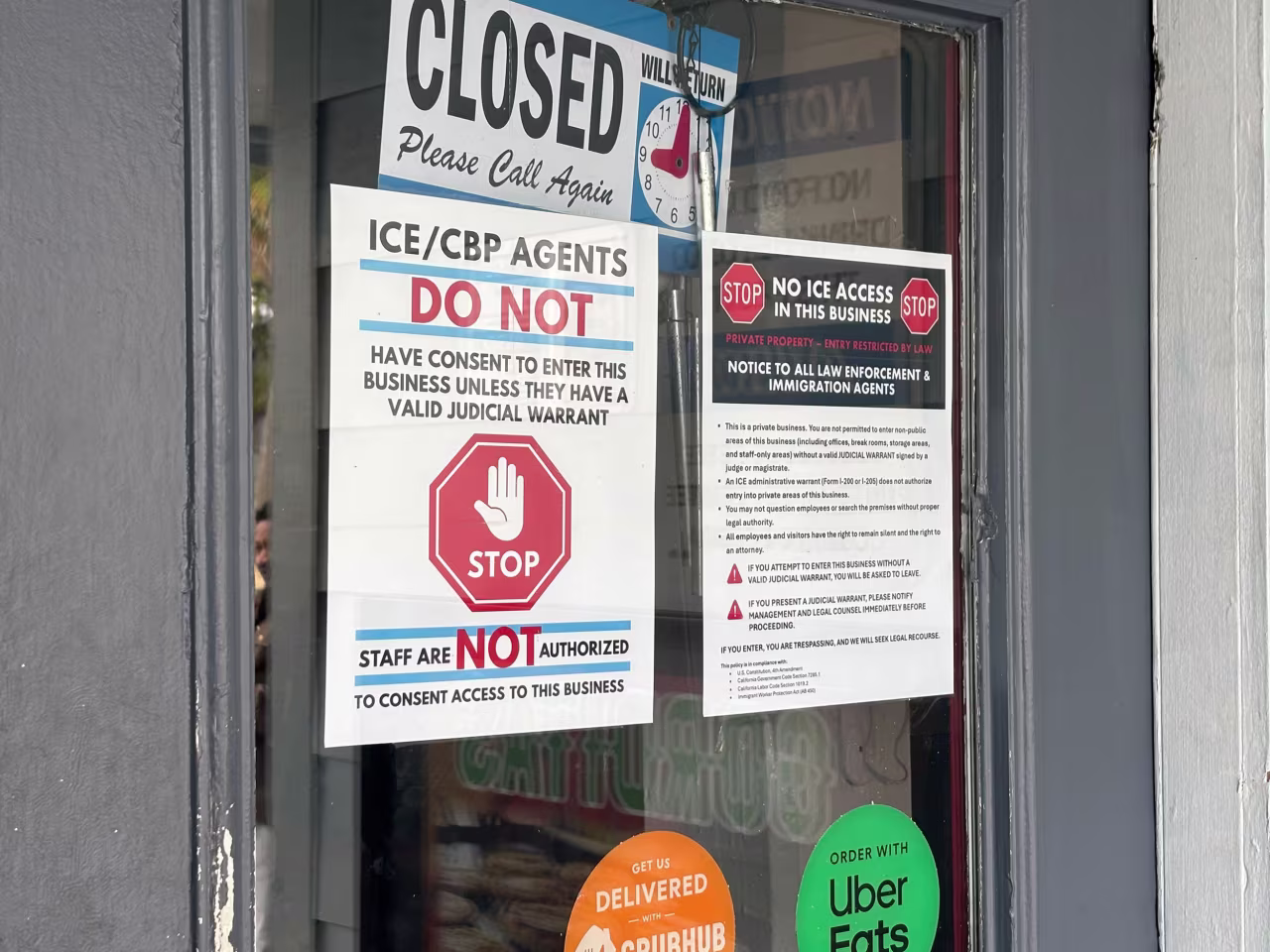 Signs are seen on the door of Taqueria Guerrero in New Orleans on Wednesday.