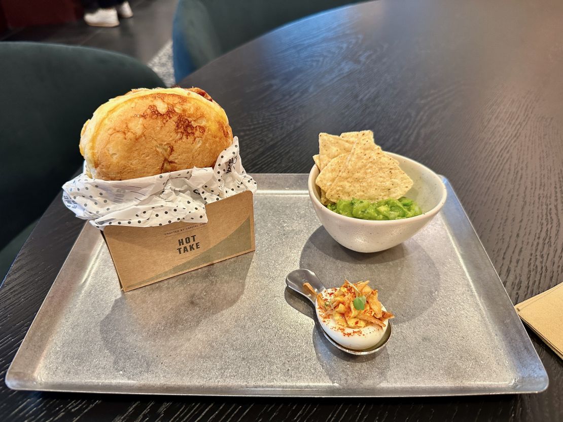 A photo of an egg sandwich, chips and guac and a deviled egg at the Capital One Lounge at Washington Dulles International Airport (IAD)