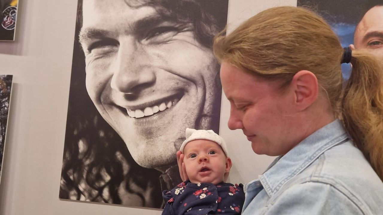 Natalia holds her daughter next to her father's photo during an exhibition in Kyiv. // Natalia says that Vitalina is becoming more and more like her father, both in appearance and emotional expressions.
