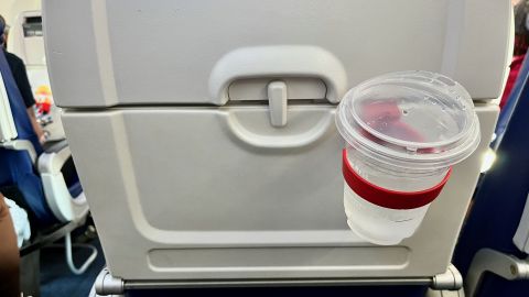 A photo of the FLYGA Airplane Drink or Phone Holder holding a cup of water 