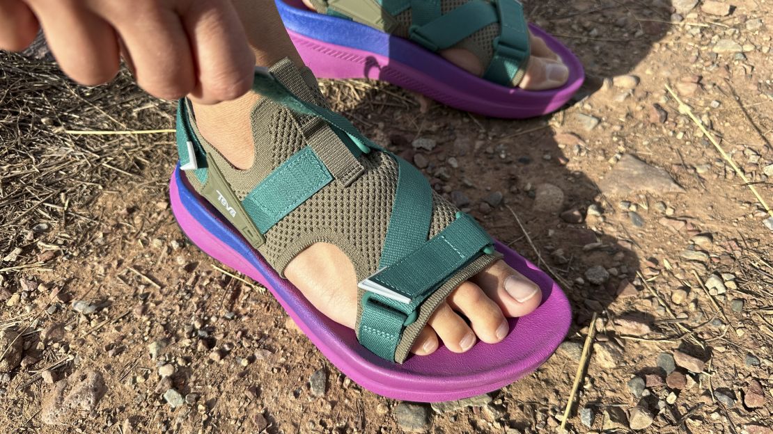 Person tightening the strap of the Teva Aventrail sandal.