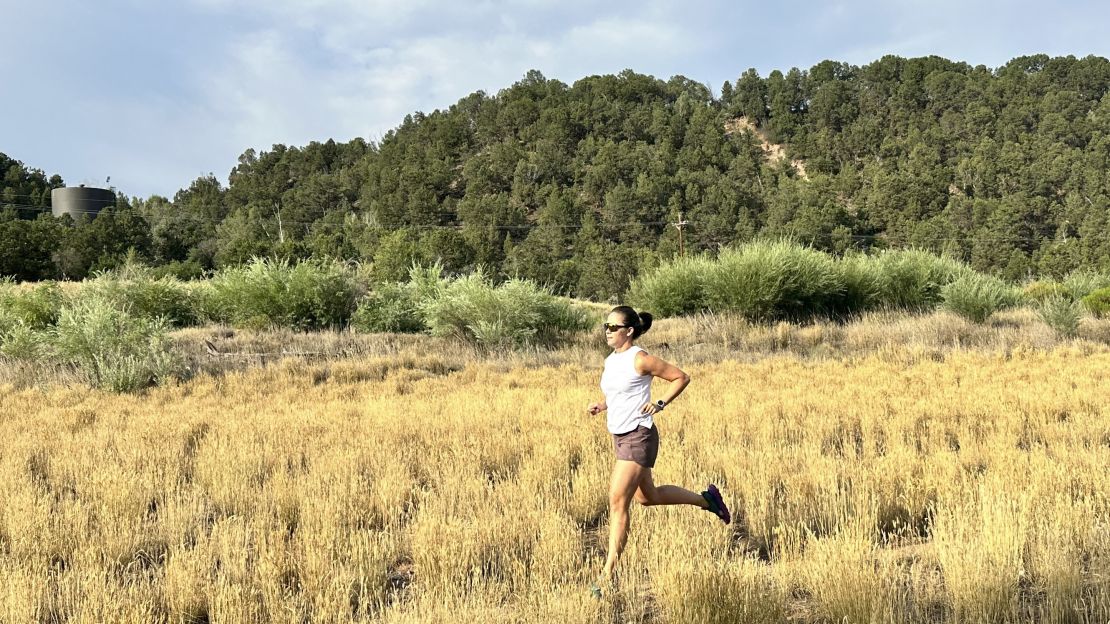 Person running outside while wearing Teva Aventrail sandals.