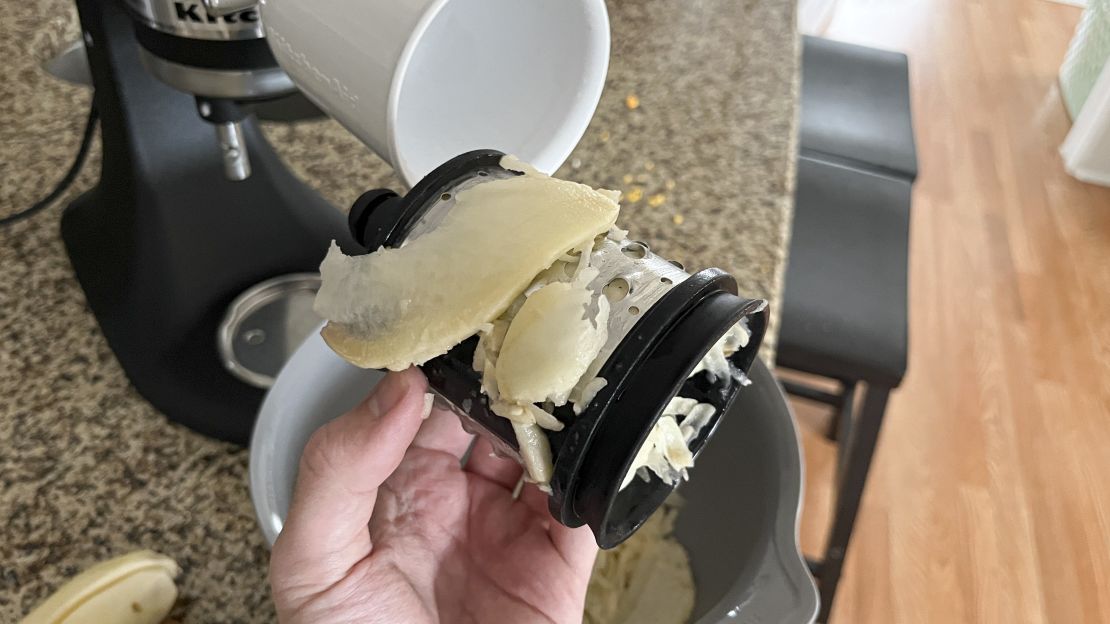 Chunky scraps of potato are stuck to the KitchenAid slicer/shredder attachment.