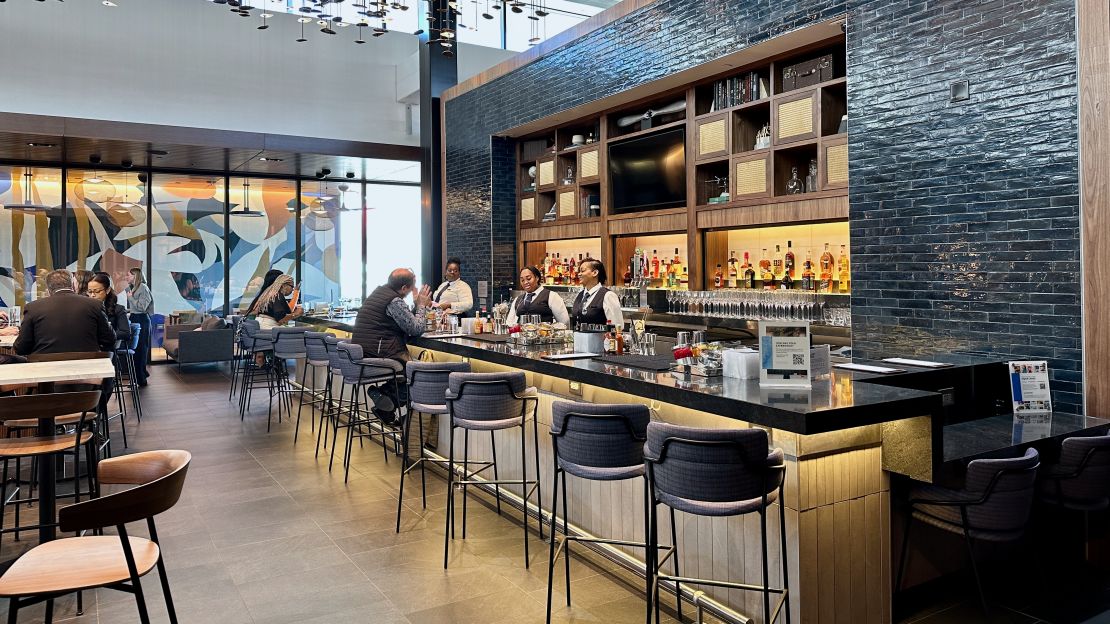 A photo of the main bar at the Atlanta Centurion Lounge with a person sitting on a barstool
