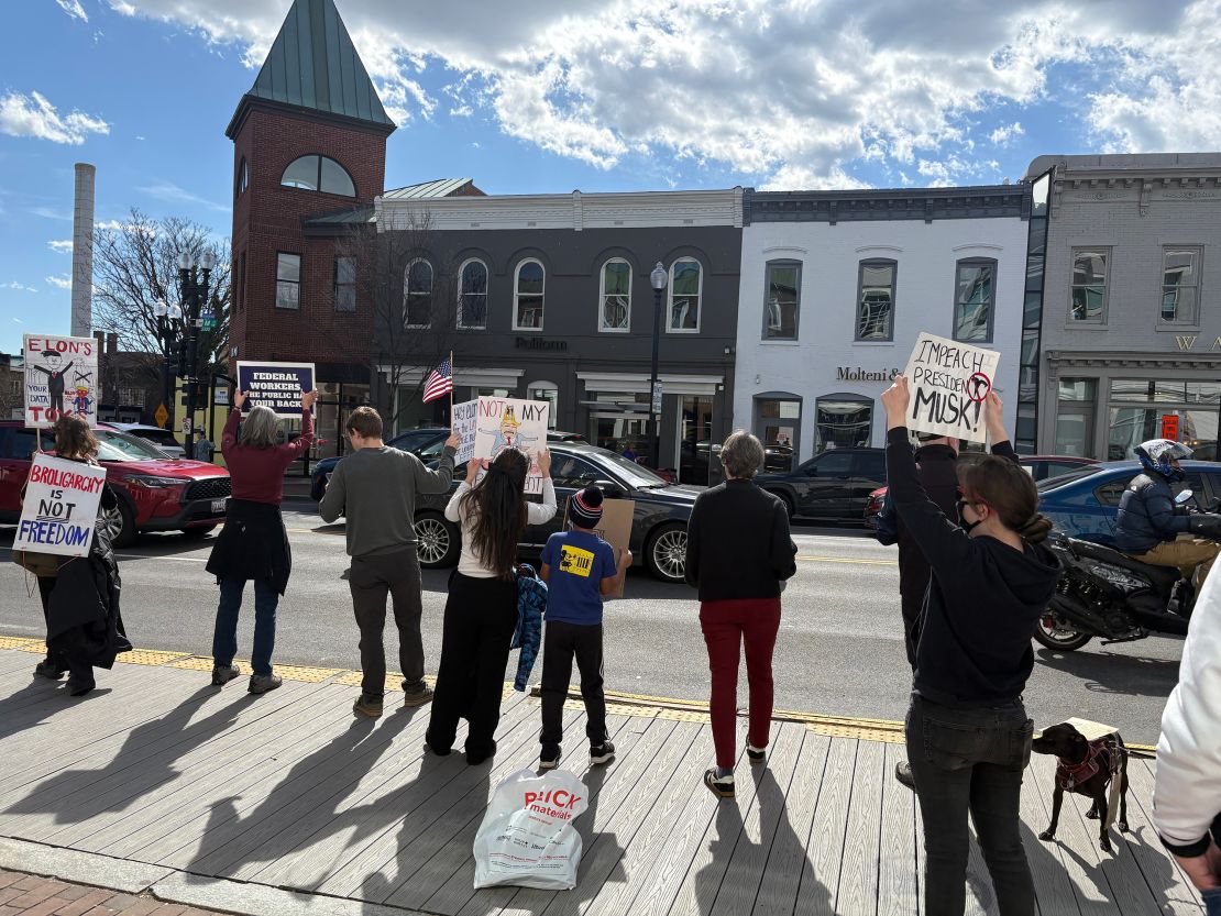 Protestors gather at a Tesla showroom in Washington, DC, chanting “DOGE needs to go” and “Who voted for Elon Musk? No one voted for Elon Musk.”