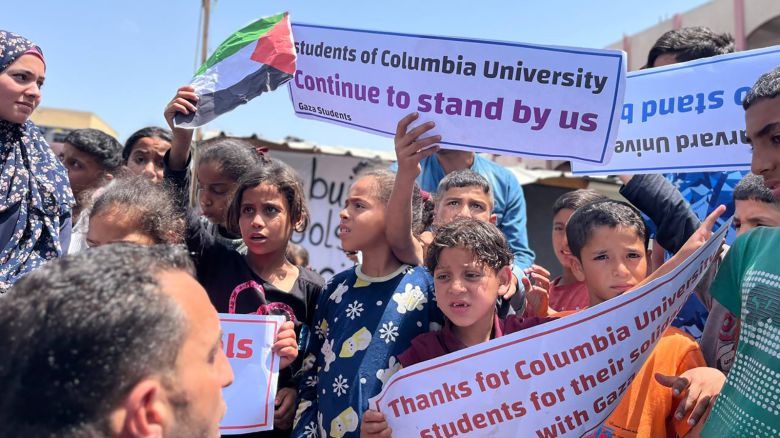 Palestinian students hold signs in Rafah, Gaza, on April 28, 2024.