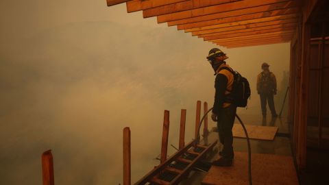 Los bomberos monitorean el avance del incendio Palisades el sábado en Mandeville Canyon en Los Ángeles.