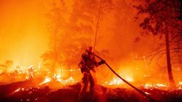 Un bombero apaga las llamas a medida que avanzan hacia las casas durante el incendio Creek en el área de Cascadel Woods del condado no incorporado de Madera, California, el 7 de septiembre de 2020.