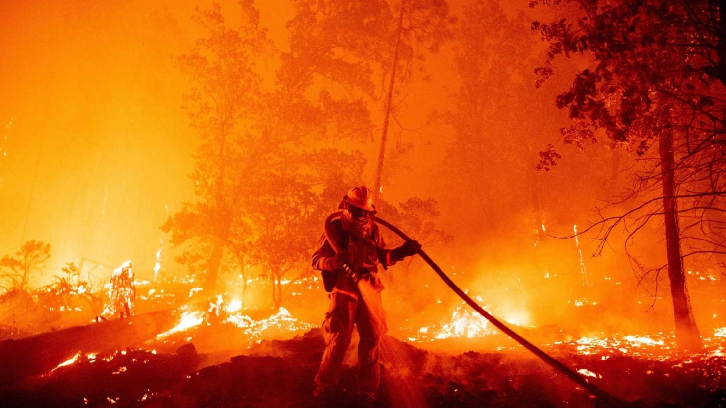 Un bombero apaga las llamas a medida que avanzan hacia las casas durante el incendio Creek en el área de Cascadel Woods del condado no incorporado de Madera, California, el 7 de septiembre de 2020.