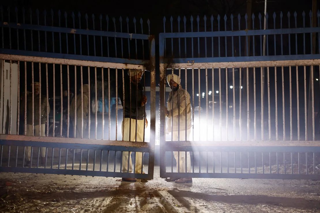 La Policía monta guardia en una puerta mientras los vehículos que transportan a los migrantes deportados abandonan el aeropuerto de Amritsar, India, el miércoles.